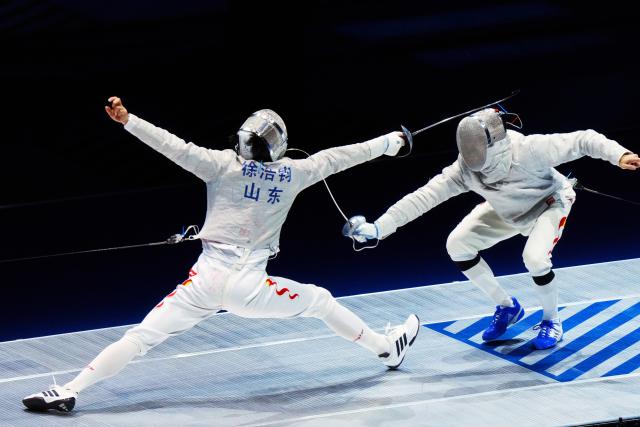 (251118) -- HONG KONG, Nov. 18, 2025 (Xinhua) -- Xu Junhao (L) of Shandong competes against Deng Xiaohao of Guangdong during the men's team sabre final of fencing at China's 15th National Games in Hong Kong, south China, Nov. 18, 2025. (Xinhua/Zhu Wei)