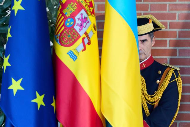 (251118) -- MADRID, Nov. 18, 2025 (Xinhua) -- A guard stands behind flags of the European Union, Spain and Ukraine during a welcome ceremony for visiting Ukrainian President Volodymyr Zelensky at La Moncloa Palace in Madrid, Spain, Nov. 18, 2025. (Xinhua/Meng Dingbo)