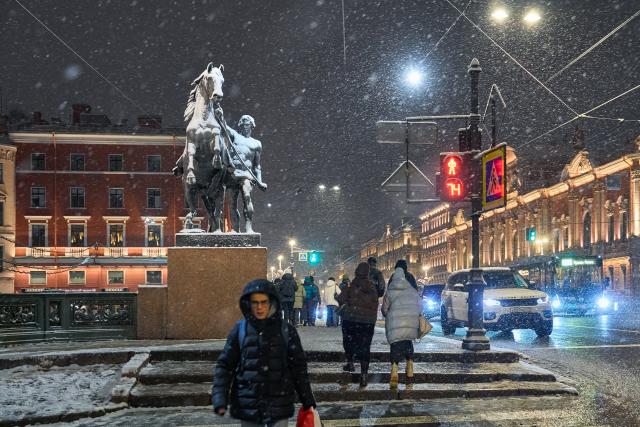 (251119) -- BEIJING, Nov. 19, 2025 (Xinhua) -- People walk on the street during a snowy night in St. Petersburg, Russia, Nov. 18, 2025. (Photo by Guo Feizhou/Xinhua)