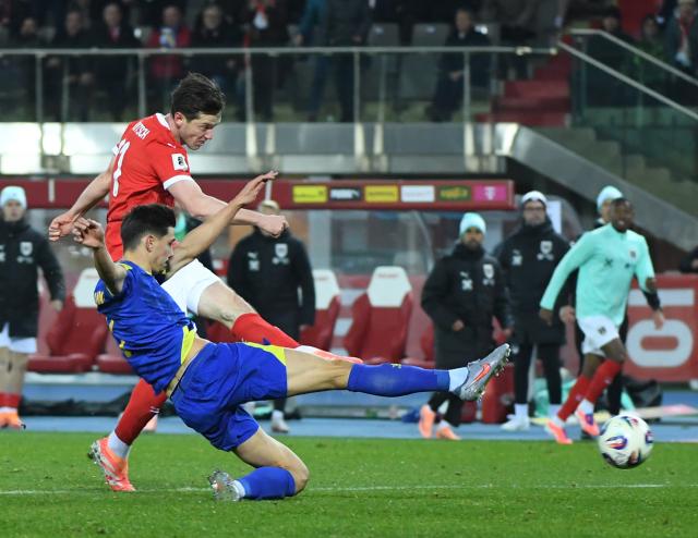(251119) -- VIENNA, Nov. 19, 2025 (Xinhua) -- Michael Gregoritsch (top) of Austria shoots during the 2026 World Cup European Qualifiers match between Austria VS Bosnia and Herzegovina in Vienna, Austria, Nov. 18, 2025. (Xinhua/He Canling)