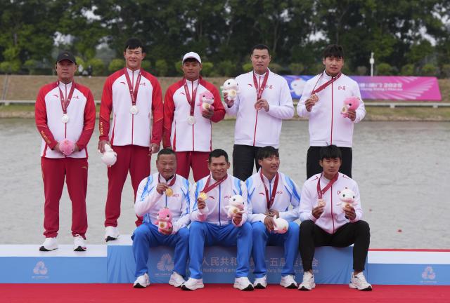 (251119) -- GUANGZHOU, Nov. 19, 2025 (Xinhua) -- Gold medalists Wang Congkang (front, 2nd L)/Xu Jiawei (front, 2nd R) of Zhejiang, silver medalists Liang Fengwei (back, 3rd L)/Chen Weiyang (back, 2nd L) of Shandong, bronze medalists Ma Fei (back, 1st R)/Wang Jinwei (front, 1st R) of Shanxi pose with their coaches during the awarding ceremony for the men's kayak double 500m of canoe sprint at China's 15th National Games in Guangzhou, south China's Guangdong Province, Nov. 19, 2025. (Xinhua/Jigme Dorji)