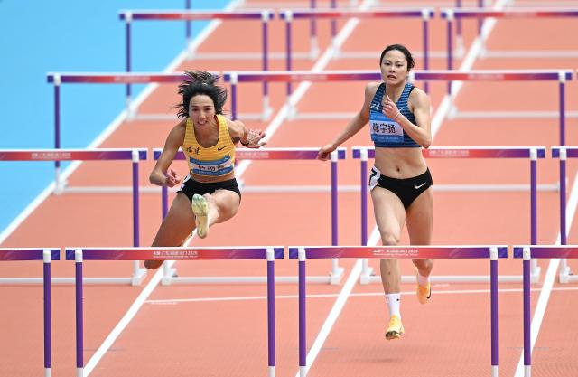 (251119) -- GUANGZHOU, Nov. 19, 2025 (Xinhua) -- Lin Yuwei (L) of Fujian competes during the women's 100m hurdles heat of athletics at China's 15th National Games in Guangzhou, south China's Guangdong Province, Nov. 19, 2025. (Xinhua/Deng Hua)