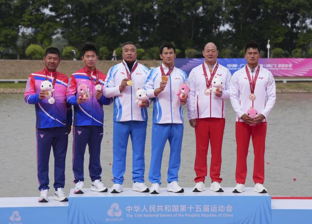 (251119) -- GUANGZHOU, Nov. 19, 2025 (Xinhua) -- Gold medalist Ji Bowen (3rd R) of Zhejiang, silver medalist Wu Shengyue (2nd L) of Shanghai, bronze medalist Liu Hao (1st R) of Yunnan pose with their coaches during the awarding ceremony for the men's canoe single 1000m of canoe sprint at China's 15th National Games in Guangzhou, south China's Guangdong Province, Nov. 19, 2025. (Xinhua/Jigme Dorji)