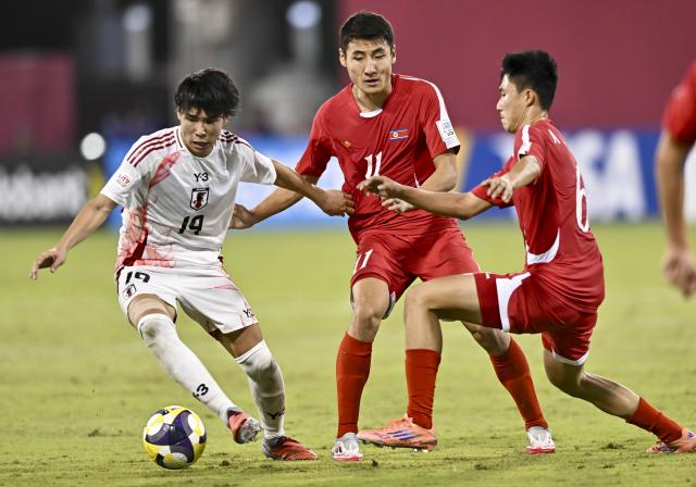 (251119) -- DOHA, Nov. 19, 2025 (Xinhua) -- Takeshi Wada (L) of Japan vies with Kang Rim Ri (C) of DPRK during the round of 16 football match between the Democratic People's Republic of Korea (DPRK) and Japan at FIFA U17 World cup Qatar 2025 in Doha, Qatar, on Nov. 18, 2025. (Photo by Nikku/Xinhua)