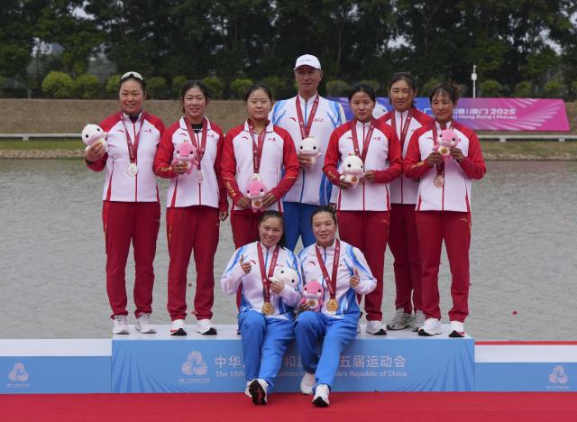 (251119) -- GUANGZHOU, Nov. 19, 2025 (Xinhua) -- Gold medalists Li Dongyin (bottom, R)/Yu Shimeng (bottom, L) of Zhejiang, silver medalists Yang Xiao (3rd L)/Ren Chunlin (2nd L) of Shandong and bronze medalists Qu Ningning (1st R)/Han Donghuan (3rd R) of Shandong pose with their coaches during the awarding ceremony for the women's kayak double 500m of canoe sprint at China's 15th National Games in Guangzhou, south China's Guangdong Province, Nov. 19, 2025. (Xinhua/Jigme Dorji)