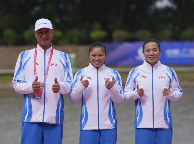 (251119) -- GUANGZHOU, Nov. 19, 2025 (Xinhua) -- Gold medalists Li Dongyin (R)/Yu Shimeng (C) of Zhejiang pose with their coach during the awarding ceremony for the women's kayak double 500m of canoe sprint at China's 15th National Games in Guangzhou, south China's Guangdong Province, Nov. 19, 2025. (Xinhua/Jigme Dorji)