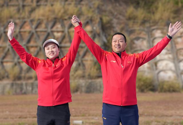 (251119) -- GUANGZHOU, Nov. 19, 2025 (Xinhua) -- Gold medalist Fan Xinyue (L) of Chongqing poses with her coach during the awarding ceremony for the trap women's final of shooting at China's 15th National Games in Guangzhou, south China's Guangdong Province, Nov. 19, 2025. (Xinhua/Xiao Ennan)