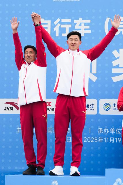 (251119) -- SHENZHEN, Nov. 19, 2025 (Xinhua) -- Silver medalist Chen Yucheng of Shandong and his coach wave during the awarding ceremony for men's cycling BMX racing at China's 15th National Games in Shenzhen, south China's Guangdong Province, Nov. 19, 2025. (Xinhua/Chen Sihan)