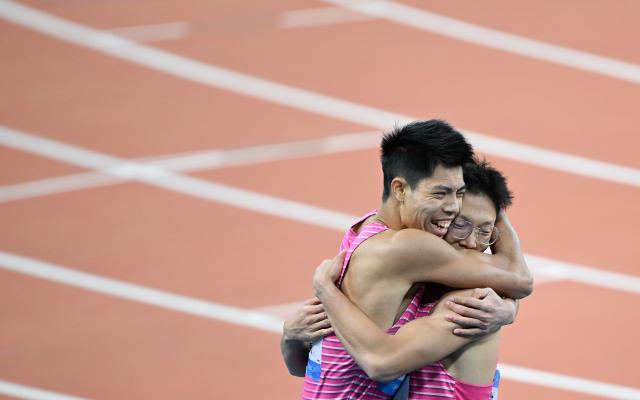 (251119) -- GUANGZHOU, Nov. 19, 2025 (Xinhua) -- Shi Junhao (R) of Guangdong hugs teammate Lin Jianhao afer the men's 200m final of athletics at China's 15th National Games in Guangzhou, south China's Guangdong Province, Nov. 19, 2025. (Xinhua/Deng Hua)