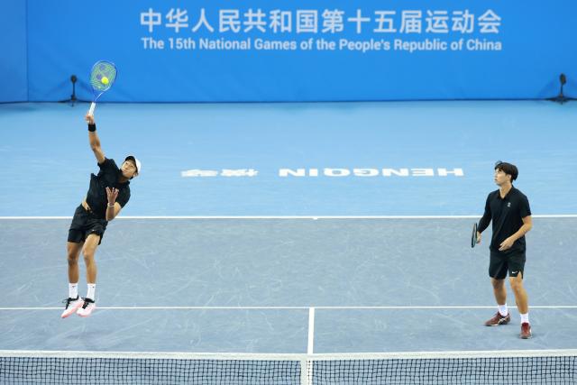 (251119) -- HENGQIN, Nov. 19, 2025 (Xinhua) -- Tang Sheng/Sun Qian (L) compete during the tennis men's doubles final between Tang Sheng/Sun Qian of Jiangsu and Bu Yunchaokete/Zheng Zhan of Zhejiang at China's 15th National Games in Hengqin, south China's Guangdong Province, Nov. 19, 2025. (Xinhua/Zhang Chenlin)
