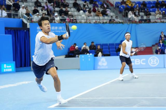(251119) -- HENGQIN, Nov. 19, 2025 (Xinhua) -- Bu Yunchaokete/Zheng Zhan (L) compete during the tennis men's doubles final between Tang Sheng/Sun Qian of Jiangsu and Bu Yunchaokete/Zheng Zhan of Zhejiang at China's 15th National Games in Hengqin, south China's Guangdong Province, Nov. 19, 2025. (Xinhua/Yan Linyun)
