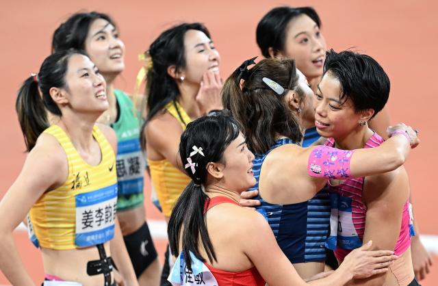 (251119) -- GUANGZHOU, Nov. 19, 2025 (Xinhua) -- Wu Yanni (C front) of Sichuan greets Liu Jingyang (R front) of Guangdong after the women's 100m hurdles final of athletics at China's 15th National Games in Guangzhou, south China's Guangdong Province, Nov. 19, 2025. (Xinhua/Deng Hua)