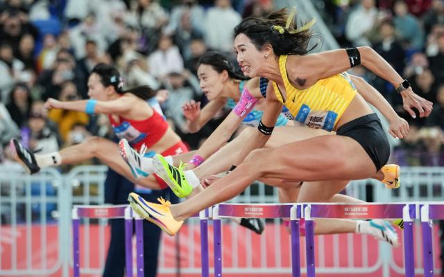 (251119) -- GUANGZHOU, Nov. 19, 2025 (Xinhua) -- Lin Yuwei (front) of Fujian competes during the women's 100m hurdles final of athletics at China's 15th National Games in Guangzhou, south China's Guangdong Province, Nov. 19, 2025. (Xinhua/Li Yibo)