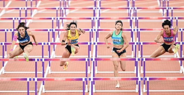 (251119) -- GUANGZHOU, Nov. 19, 2025 (Xinhua) -- Liu Jingyang (1st R) of Guangdong and Wu Yanni (1st L) of Sichuan compete during the women's 100m hurdles final of athletics at China's 15th National Games in Guangzhou, south China's Guangdong Province, Nov. 19, 2025. (Xinhua/Deng Hua)