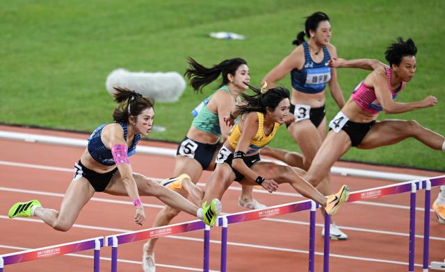 (251119) -- GUANGZHOU, Nov. 19, 2025 (Xinhua) -- Wu Yanni (1st L) of Sichuan and Liu Jingyang (1st R) of Guangdong compete during the women's 100m hurdles final of athletics at China's 15th National Games in Guangzhou, south China's Guangdong Province, Nov. 19, 2025. (Xinhua/Zhou Mu)