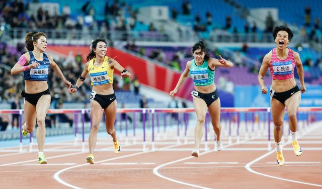 (251119) -- GUANGZHOU, Nov. 19, 2025 (Xinhua) -- Wu Yanni (1st L) of Sichuan and Liu Jingyang (1st R) of Guangdong cross the finish line during the women's 100m hurdles final of athletics at China's 15th National Games in Guangzhou, south China's Guangdong Province, Nov. 19, 2025. (Xinhua/Huang Wei)