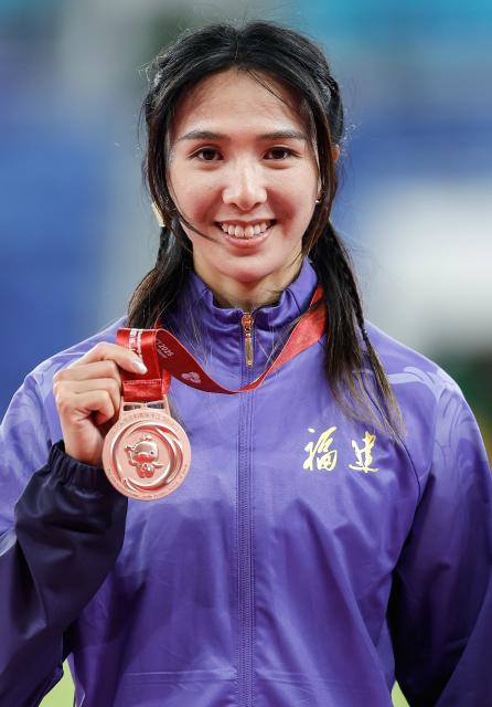 (251119) -- GUANGZHOU, Nov. 19, 2025 (Xinhua) -- Bronze medalist Lin Yuwei of Fujian poses during the awarding ceremony for the women's 100m hurdles of athletics at China's 15th National Games in Guangzhou, south China's Guangdong Province, Nov. 19, 2025. (Xinhua/Zhou Mu)