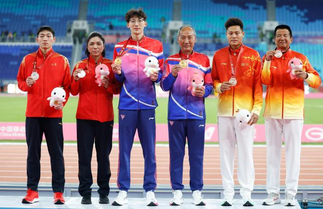 (251119) -- GUANGZHOU, Nov. 19, 2025 (Xinhua) -- Gold medalist Xu Zhuoyi of Shanghai, silver medalist Liu Junxi of Jiangsu and bronze medalist Zhu Shenglong of Hubei pose with their coaches during the awarding ceremony for the men's 110m hurdles of athletics at China's 15th National Games in Guangzhou, south China's Guangdong Province, Nov. 19, 2025. (Xinhua/Huang Wei)