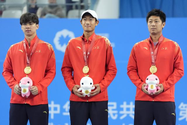 (251119) -- HENGQIN, Nov. 19, 2025 (Xinhua) -- Gold medalists Tang Sheng/Sun Qian of Jiangsu pose with their coach during the awarding ceremony for the men's doubles of tennis at China's 15th National Games in Hengqin, south China's Guangdong Province, Nov. 19, 2025. (Xinhua/Yan Linyun)