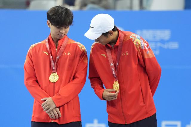 (251119) -- HENGQIN, Nov. 19, 2025 (Xinhua) -- Gold medalists Tang Sheng/Sun Qian of Jiangsu react during the awarding ceremony for the men's doubles of tennis at China's 15th National Games in Hengqin, south China's Guangdong Province, Nov. 19, 2025. (Xinhua/Yan Linyun)