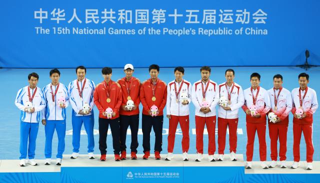 (251119) -- HENGQIN, Nov. 19, 2025 (Xinhua) -- Gold medalists Tang Sheng/Sun Qian of Jiangsu, silver medalists Bu Yunchaokete/Zheng Zhan of Zhejiang, bronze medalists Zeng Yaojie/Yang Zijiang of Guangdong and bronze medalist Cui Jie/Terigele of Beijing pose with their coaches during the awarding ceremony for the men's doubles of tennis at China's 15th National Games in Hengqin, south China's Guangdong Province, Nov. 19, 2025. (Xinhua/Zhang Chenlin)