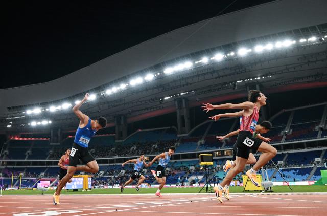 (251119) -- GUANGZHOU, Nov. 19, 2025 (Xinhua) -- Xu Zhuoyi (front R) of Shanghai crosses the finish line during the men's 110m hurdles final of athletics at China's 15th National Games in Guangzhou, south China's Guangdong Province, Nov. 19, 2025. (Xinhua/Jiang Han)
