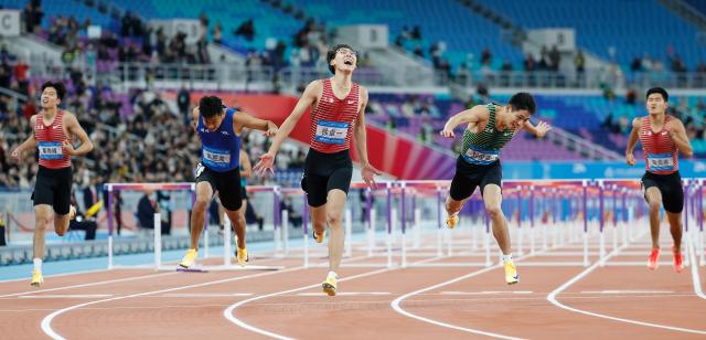 (251119) -- GUANGZHOU, Nov. 19, 2025 (Xinhua) -- Xu Zhuoyi (C) of Shanghai crosses the finish line during the men's 110m hurdles final of athletics at China's 15th National Games in Guangzhou, south China's Guangdong Province, Nov. 19, 2025. (Xinhua/Huang Wei)
