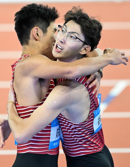 (251119) -- GUANGZHOU, Nov. 19, 2025 (Xinhua) -- Xu Zhuoyi (R) of Shanghai hugs his teammate Chen Yuanjiang after the men's 110m hurdles final of athletics at China's 15th National Games in Guangzhou, south China's Guangdong Province, Nov. 19, 2025. (Xinhua/Deng Hua)