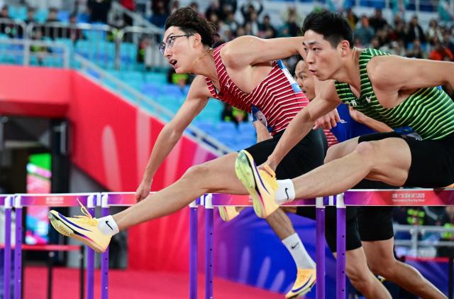 (251119) -- GUANGZHOU, Nov. 19, 2025 (Xinhua) -- Xu Zhuoyi (L) of Shanghai and Liu Junxi of Jiangsu compete during the men's 110m hurdles final of athletics at China's 15th National Games in Guangzhou, south China's Guangdong Province, Nov. 19, 2025. (Xinhua/Jiang Han)