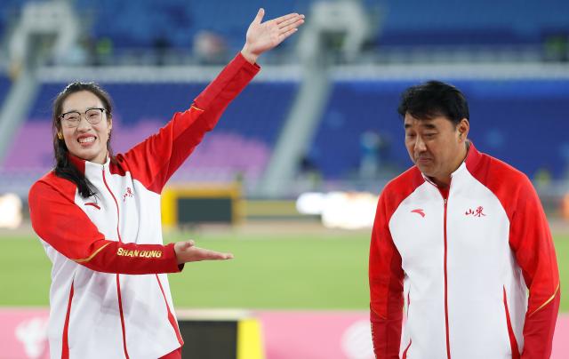 (251119) -- GUANGZHOU, Nov. 19, 2025 (Xinhua) -- Gold medalist Feng Bin (L) of Shandong reacts during the awarding ceremony for the women's discus throw of athletics at China's 15th National Games in Guangzhou, south China's Guangdong Province, Nov. 19, 2025. (Xinhua/Huang Wei)
