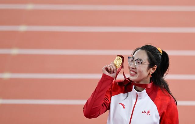 (251119) -- GUANGZHOU, Nov. 19, 2025 (Xinhua) -- Gold medalist Feng Bin of Shandong reacts during the awarding ceremony for the women's discus throw of athletics at China's 15th National Games in Guangzhou, south China's Guangdong Province, Nov. 19, 2025. (Xinhua/Zhou Mu)