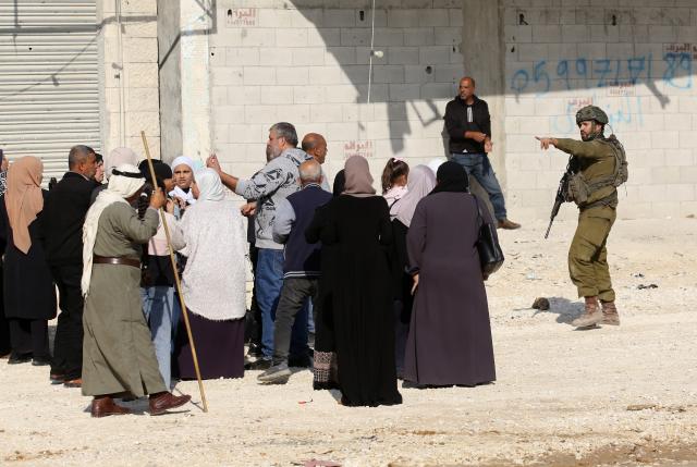 (251119) -- TULKARM, Nov. 19, 2025 (Xinhua) -- An Israeli soldier tries to prevent Palestinians from reaching their houses in Nur Shams refugee camp in the West Bank city of Tulkarm, Nov. 18, 2025. Palestinians took part in a demonstration demanding the right to return to their houses at the entrance of Nur Shams refugee camp, while Israeli soldiers assaulted the crowd and forced them to leave the area. (Photo by Nidal Eshtayeh/Xinhua)