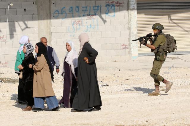 (251119) -- TULKARM, Nov. 19, 2025 (Xinhua) -- An Israeli soldier tries to prevent Palestinians from reaching their houses in Nur Shams refugee camp in the West Bank city of Tulkarm, Nov. 18, 2025. Palestinians took part in a demonstration demanding the right to return to their houses at the entrance of Nur Shams refugee camp, while Israeli soldiers assaulted the crowd and forced them to leave the area. (Photo by Nidal Eshtayeh/Xinhua)