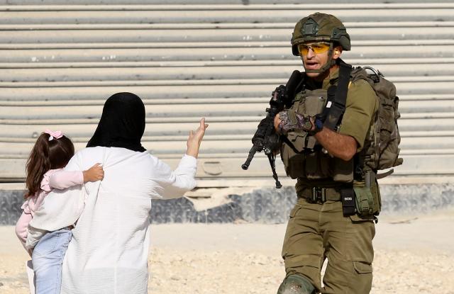 (251119) -- TULKARM, Nov. 19, 2025 (Xinhua) -- An Israeli soldier tries to prevent Palestinians from reaching their houses in Nur Shams refugee camp in the West Bank city of Tulkarm, Nov. 18, 2025. Palestinians took part in a demonstration demanding the right to return to their houses at the entrance of Nur Shams refugee camp, while Israeli soldiers assaulted the crowd and forced them to leave the area. (Photo by Nidal Eshtayeh/Xinhua)