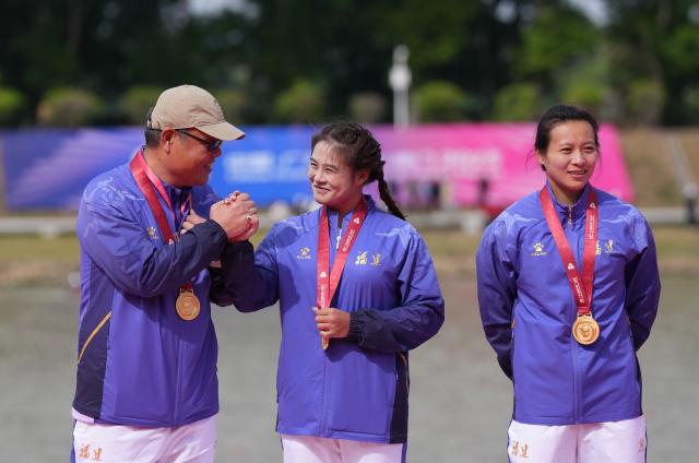 (251120) -- GUANGZHOU, Nov. 20, 2025 (Xinhua) -- Gold medalists Lin Xialian (C)/Lin Wenjun (R) react during the awarding ceremony for women's canoe double 200m of canoe sprint at China's 15th National Games in Guangzhou, south China's Guangdong Province, Nov. 20, 2025. (Xinhua/Jigme Dorji)
