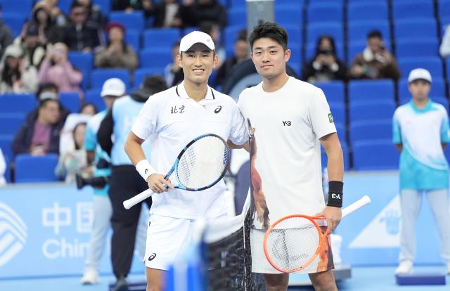 (251120) -- HENGQIN, Nov. 20, 2025 (Xinhua) -- Shang Juncheng (L) and Wu Yibing pose for photos before the tennis men's singles final between Shang Juncheng of Beijing and Wu Yibing of Zhejiang at China's 15th National Games in Hengqin, south China's Guangdong Province, Nov. 20, 2025. (Xinhua/Yan Linyun)