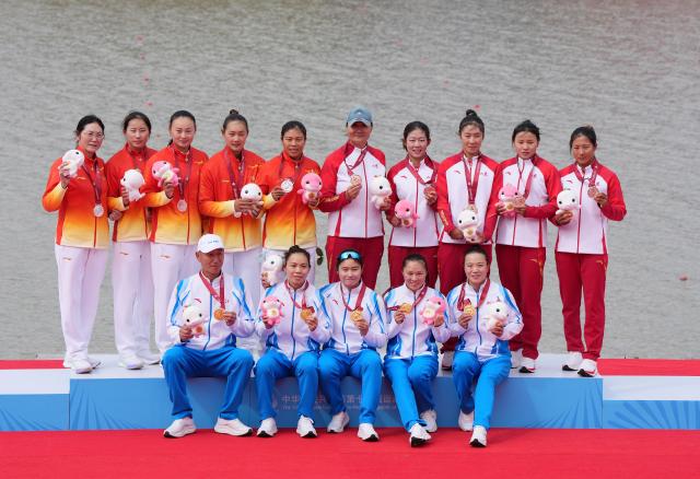 (251120) -- GUANGZHOU, Nov. 20, 2025 (Xinhua) -- Gold medalists team Zhejiang (bottom), silver medalists team Hubei (top L), bronze medalists team Shandong pose during the awarding ceremony for the women's kayak four 500m of canoe sprint at China's 15th National Games in Guangzhou, south China's Guangdong Province, Nov. 20, 2025. (Xinhua/Jigme Dorji)