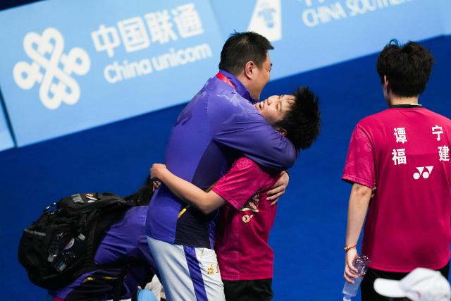 (251120) -- SHENZHEN, Nov. 20, 2025 (Xinhua) -- Huang Dongping (C) celebrates with her coach after the women's doubles final match of badminton between Huang Dongping/Tan Ning of Fujian and Zheng Yu/Zhang Shuxian of Sichuan at China's 15th National Games in Shenzhen, south China's Guangdong Province, Nov. 20, 2025. (Xinhua/Chen Sihan)