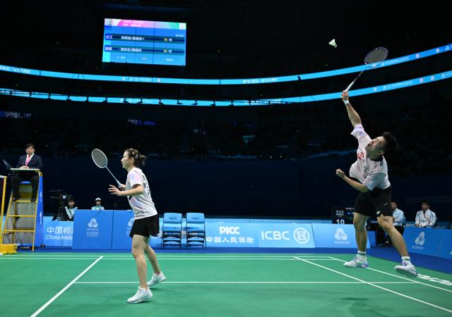 (251120) -- SHENZHEN, Nov. 20, 2025 (Xinhua) -- Zheng Siwei (R)/Huang Yaqiong of Zhejiang compete during the mixed doubles final of badminton against Zhou Zhihong/Wei Yaxin of Hunan at China's 15th National Games in Shenzhen, south China's Guangdong Province, Nov. 20, 2025. (Xinhua/Li Ziheng)