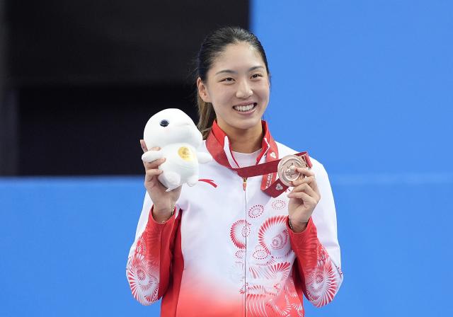 (251120) -- HENGQIN, Nov. 20, 2025 (Xinhua) -- Bronze medalist Wang Xinyu of Guangdong celebrates during the awarding ceremony for the women's singles of tennis at China's 15th National Games in Hengqin, south China's Guangdong Province, Nov. 20, 2025. (Xinhua/Yan Linyun)