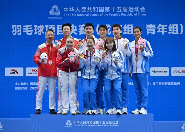 (251120) -- SHENZHEN, Nov. 20, 2025 (Xinhua) -- Gold medalists Zheng Siwei/Huang Yaqiong of Zhejiang, silver medalists Zhou Zhihong/Wei Yaxin of Hunan and bronze medalists Guo Xinwa/Wu Mengying of Zhejiang pose with their coaches during the awarding ceremony for the mixed doubles of badminton at China's 15th National Games in Shenzhen, south China's Guangdong Province, Nov. 20, 2025. (Xinhua/Li Ziheng)