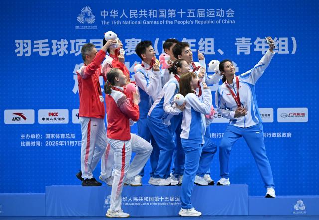 (251120) -- SHENZHEN, Nov. 20, 2025 (Xinhua) -- Gold medalists Zheng Siwei/Huang Yaqiong of Zhejiang, silver medalists Zhou Zhihong/Wei Yaxin of Hunan and bronze medalists Guo Xinwa/Wu Mengying of Zhejiang and their coaches pose for a selfie after the awarding ceremony for the mixed doubles of badminton at China's 15th National Games in Shenzhen, south China's Guangdong Province, Nov. 20, 2025. (Xinhua/Li Ziheng)