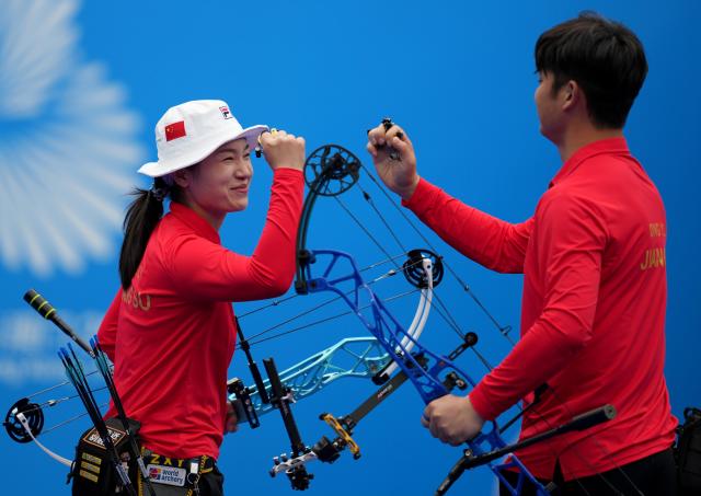 (251120) -- SHENZHEN, Nov. 20, 2025 (Xinhua) -- Zhang Xinyan/Ding Yiliang of Jiangsu cheer for each other before the mixed team compound final of archery at China's 15th National Games in Shenzhen, south China's Guangdong Province, Nov. 20, 2025. (Xinhua/Hao Yuan)