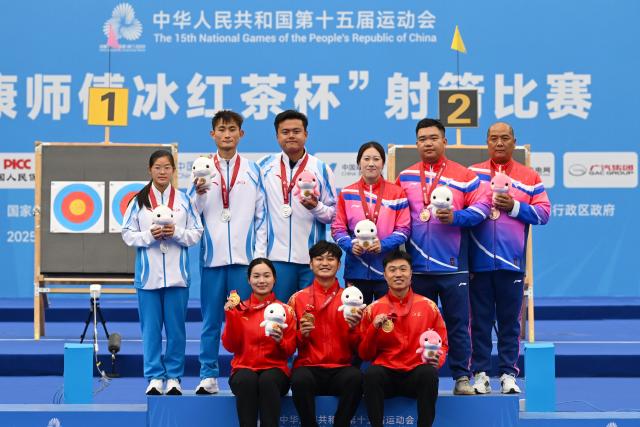(251120) -- SHENZHEN, Nov. 20, 2025 (Xinhua) -- Gold medalists Zhang Xinyan/Ding Yiliang of Jiangsu, silver medalists Li Xinxu/Zheng Xinghuan of Zhejiang and bronze medalists Yao Yao/Zhang Zilei of Shanghai pose with their coaches during the awarding ceremony for the mixed team compound of archery at China's 15th National Games in Shenzhen, south China's Guangdong Province, Nov. 20, 2025. (Xinhua/Hao Yuan)