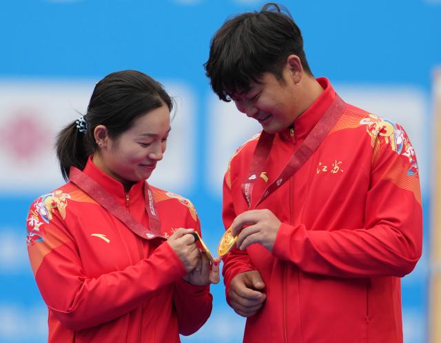 (251120) -- SHENZHEN, Nov. 20, 2025 (Xinhua) -- Gold medalists Zhang Xinyan/Ding Yiliang of Jiangsu react during the awarding ceremony for the mixed team compound of archery at China's 15th National Games in Shenzhen, south China's Guangdong Province, Nov. 20, 2025. (Xinhua/Hao Yuan)