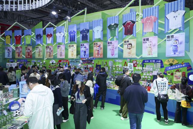 (251120) -- SHANGHAI, Nov. 20, 2025 (Xinhua) -- Visitors view cultural and creative products of the Jiangsu Football City League at an exhibition area of east China's Jiangsu Province during the 6th Yangtze River Delta International Cultural Industries Expo in east China's Shanghai, Nov. 20, 2025. Covering an area of 80,000 square meters, the expo kicked off in Shanghai on Thursday, with more than 1,500 exhibitors participating. (Xinhua/Wang Xiang)