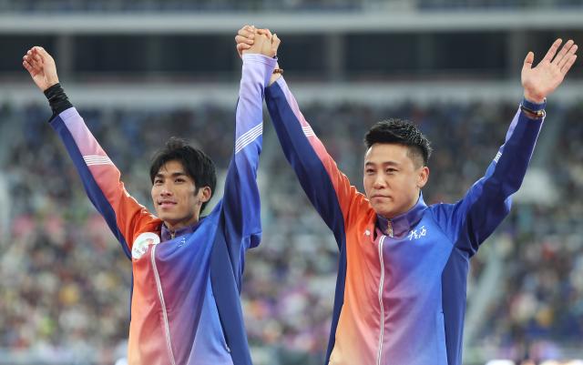 (251120) -- GUANGZHOU, Nov. 20, 2025 (Xinhua) -- Gold medalist Liu Dezhu (L) of Guangxi and his coach wave during the awarding ceremony for the men's 1500m of athletics at China's 15th National Games in Guangzhou, south China's Guangdong Province, Nov. 20, 2025. (Xinhua/Huang Wei)