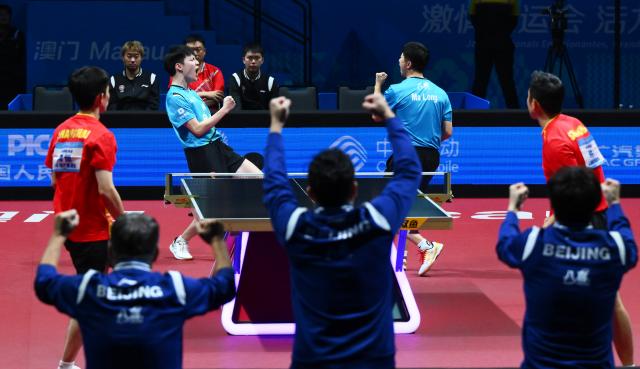 (251120) -- MACAO, Nov. 20, 2025 (Xinhua) -- Ma Long (back L)/Huang Youzheng (back R) of Beijing celebrate scoring in the match against Xu Xin/Zhou Kai of Shanghai during the men's team final of table tennis between Beijing and Shanghai at China's 15th National Games in Macao, south China, Nov. 20, 2025. (Xinhua/Cheong Kam Ka)