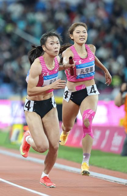 (251120) -- GUANGZHOU, Nov. 20, 2025 (Xinhua) -- Kong Yingying (R) of team Guangdong passes the baton to her teammate Liang Nuo during the women's 4x400m relay final of athletics at China's 15th National Games in Guangzhou, south China's Guangdong Province, Nov. 20, 2025. (Xinhua/Huang Wei)