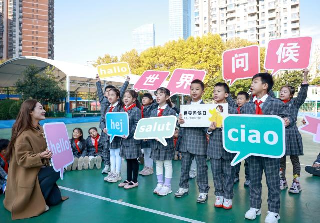(251120) -- BEIJING, Nov. 20, 2025 (Xinhua) -- A teacher teaches children greeting etiquette to celebrate the upcoming World Hello Day, which falls on Nov. 21 annually, at a primary school in Wuhan, central China's Hubei Province, Nov. 20, 2025. (Photo by Zhao Jun/Xinhua)